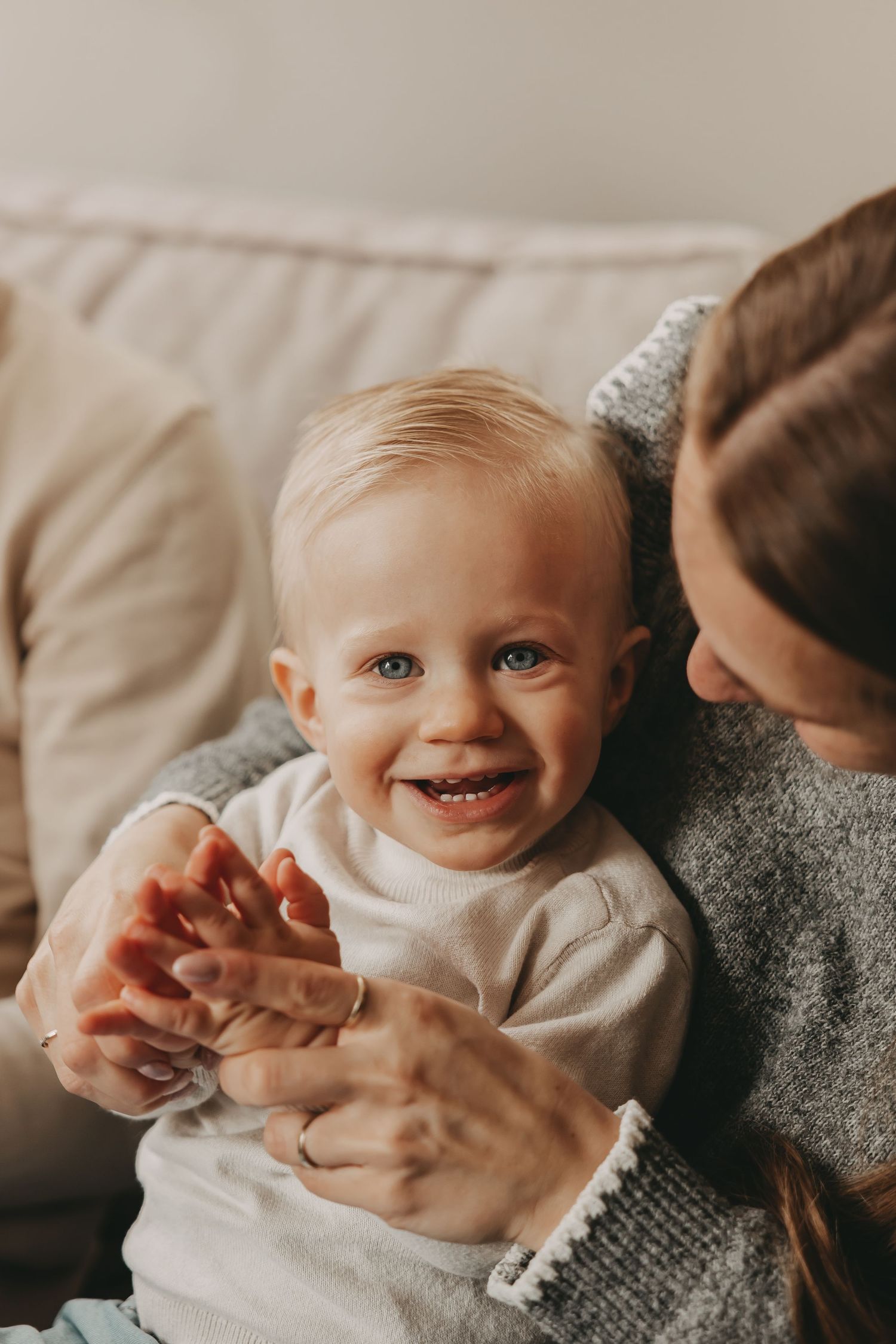 Een blij jongentje die grote broer is geworden tijdens een newborn fotoshoot.