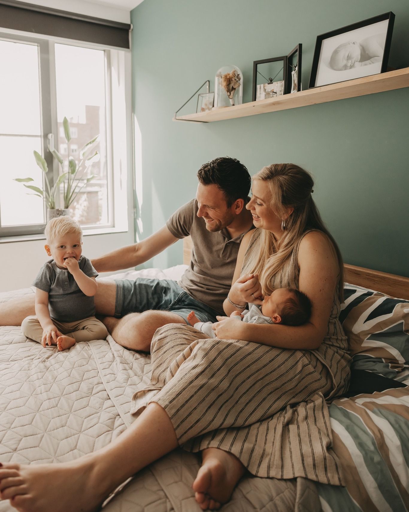 Met elkaar knuffelen op bed tijdens een newborn fotoshoot.