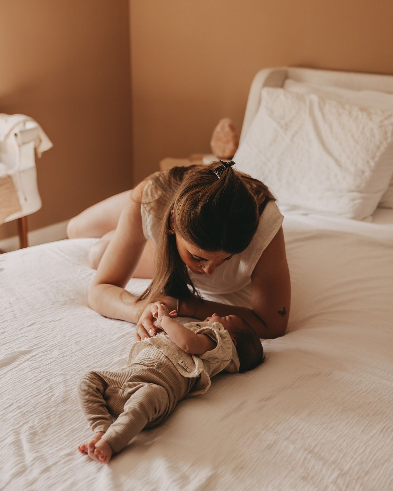 Een mama knuffelt haar newborn baby tijdens een newborn fotoshoot.