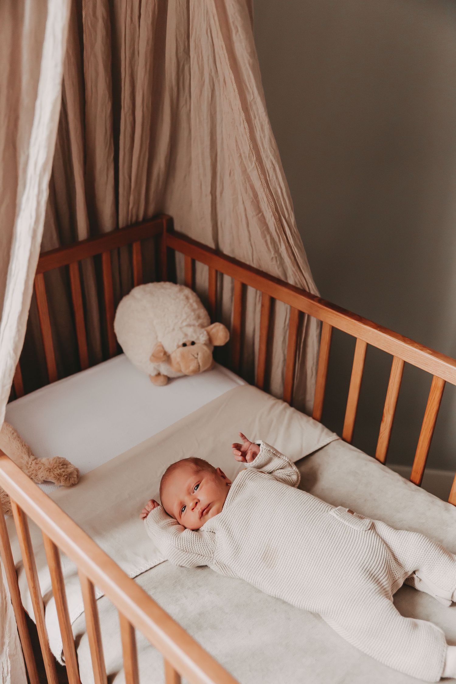 Een newborn baby voor het eerst in eigen bedje tijdens een newborn fotoshoot.