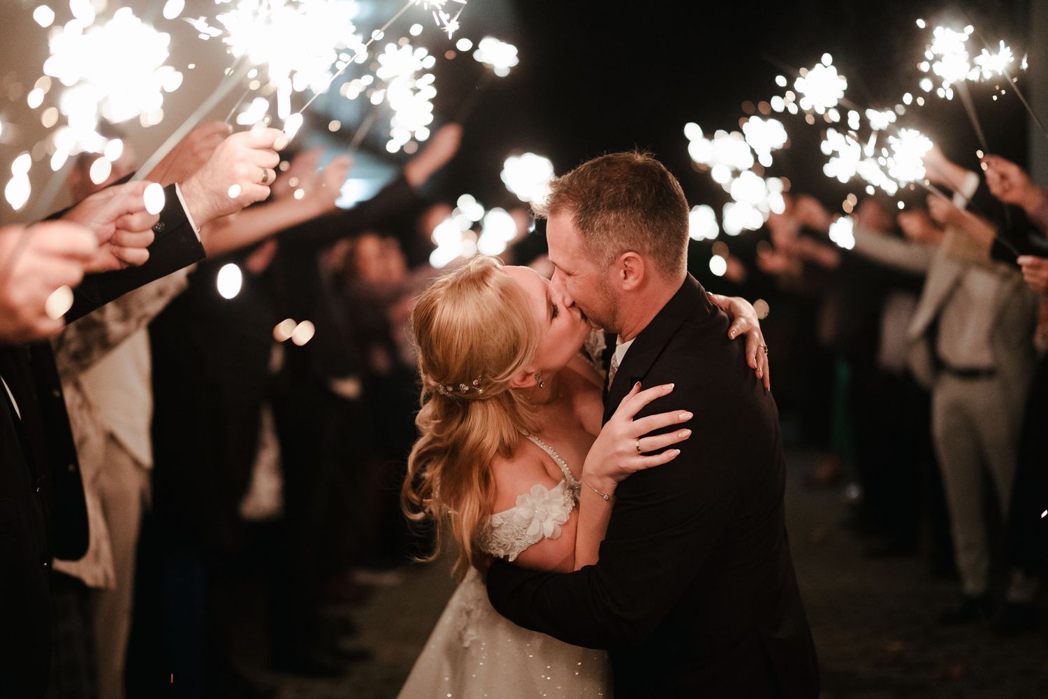 Sparkler exit celebration at night creates magical atmosphere for newlyweds.