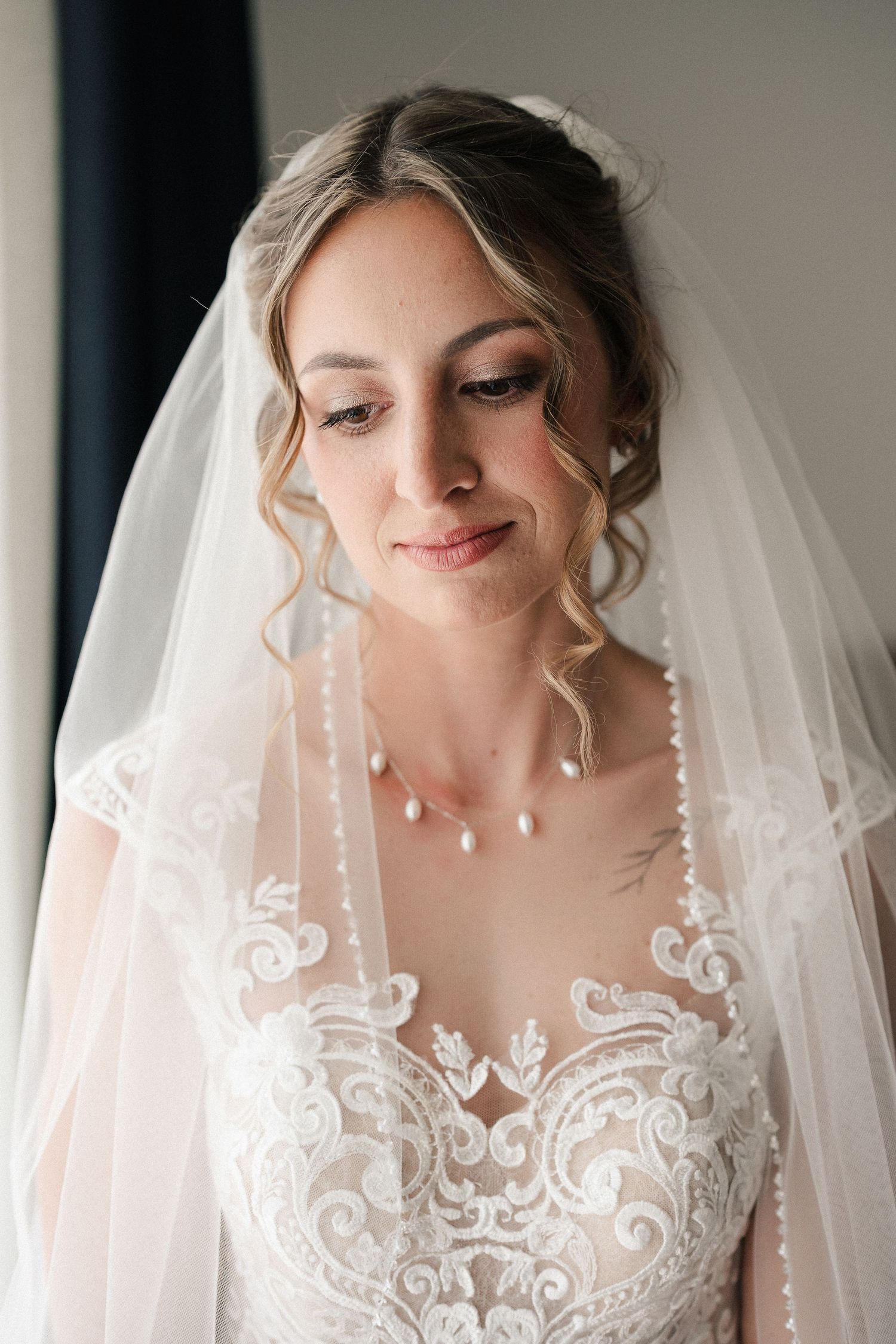 Detailed shots of intricate lace wedding veil with delicate embroidery patterns.