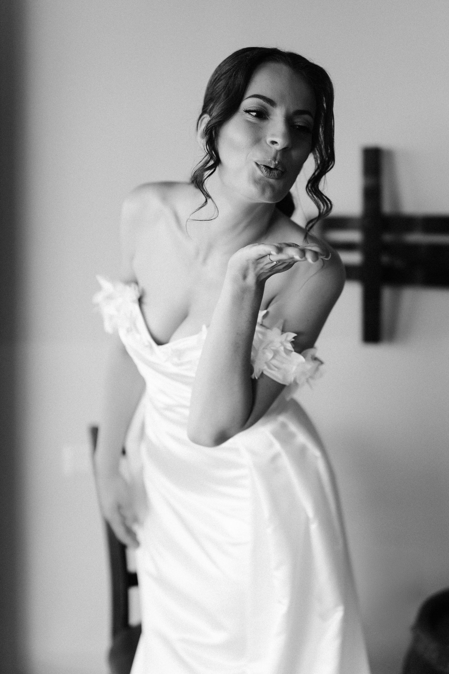 Artistic black and white portrait of someone in a flowing white dress getting ready.