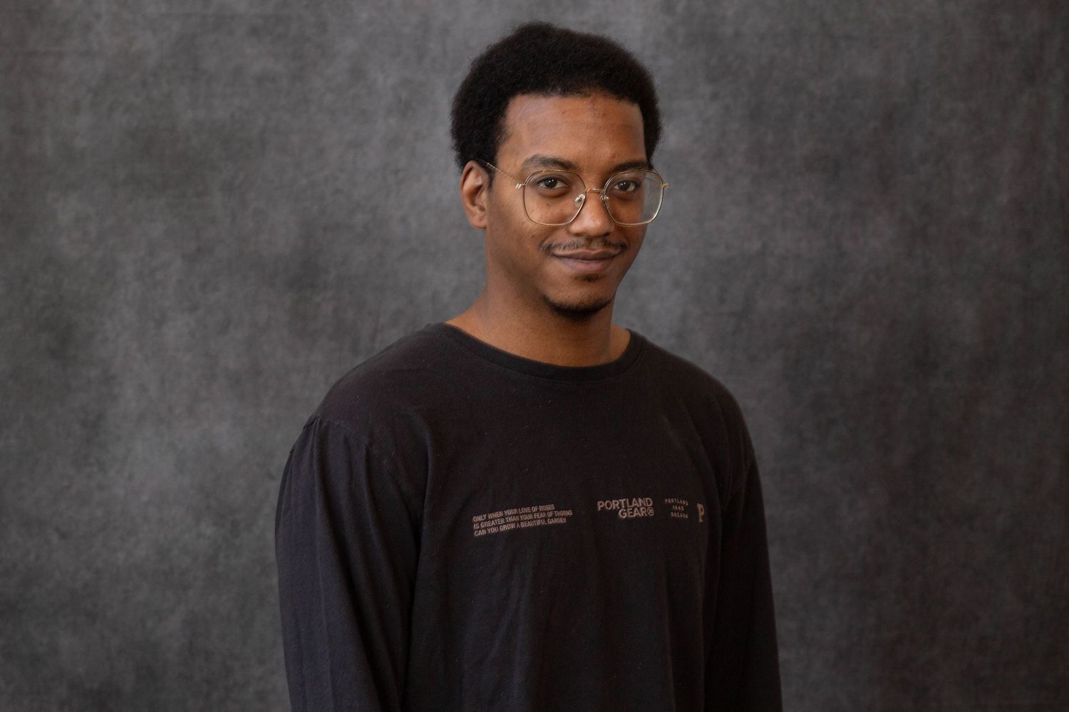 A series of professional headshots of someone wearing a black shirt against a gray textured background.