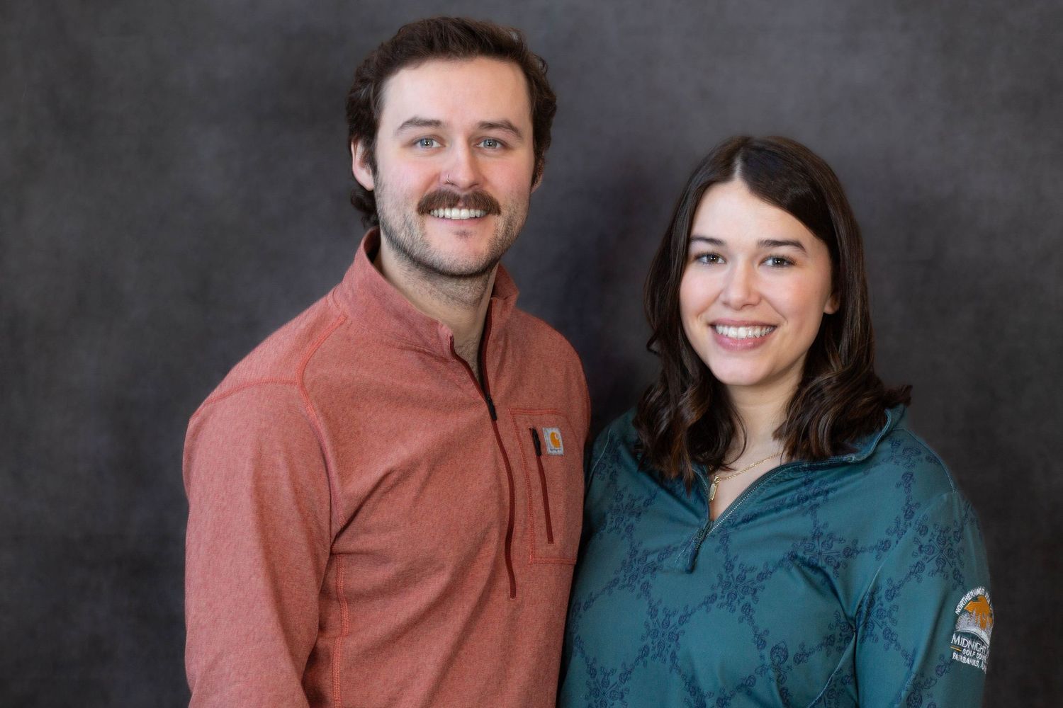 A couple wearing casual attire poses together against a dark background in a series of candid shots.