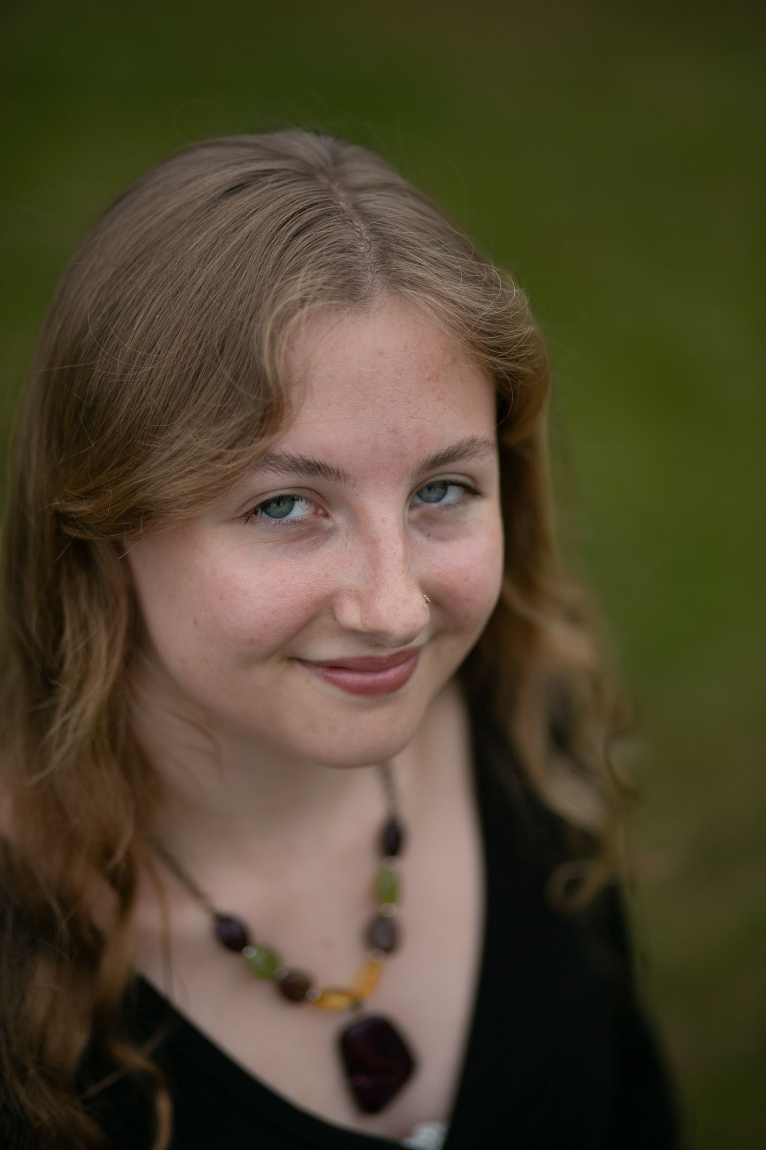 Portrait series showing warm expressions and black necklace against dark background.