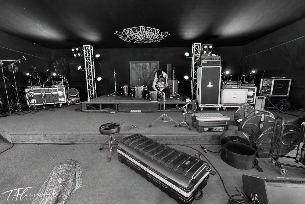 Wide panoramic view of an empty concert stage with equipment and instruments.