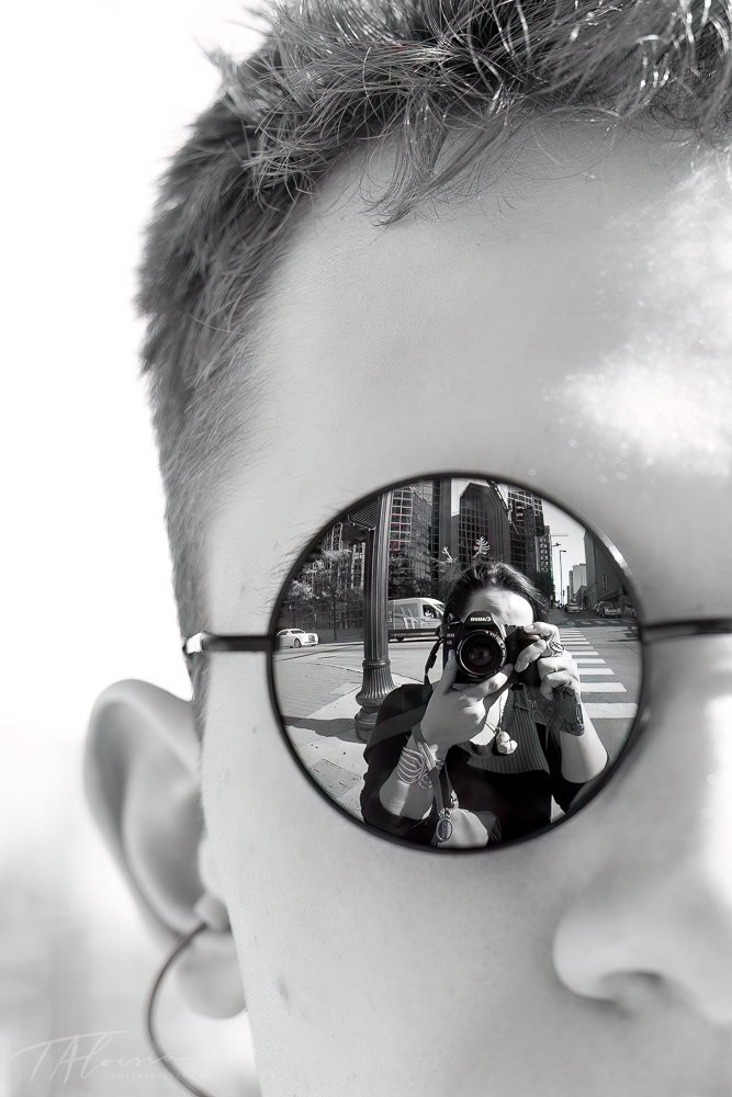 Close-up side view of sunglasses with urban reflection.