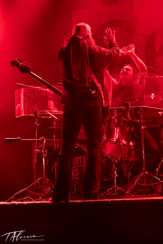 Concert performance sequence in vivid red lighting showing musicians on stage.