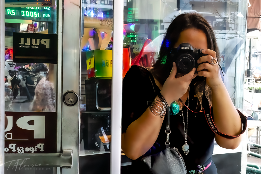 Multiple reflections in store windows showing photographer taking pictures.
