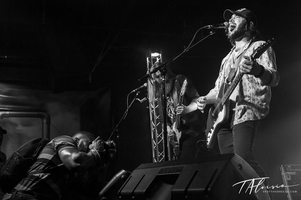 Black and white panorama of musicians performing on stage with instruments.