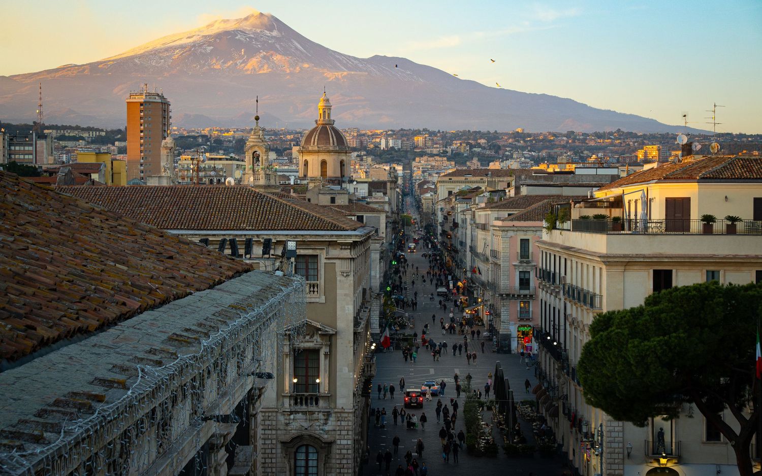 Vista panoramica di Catania dal centro storico con l’Etna al tramonto, fotografia urbana e paesaggistica siciliana.