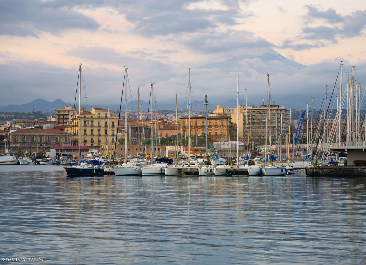 Foto paesaggistica di Catania, vista dal porto. Il mare in primo piano, l'Etna sullo sfondo