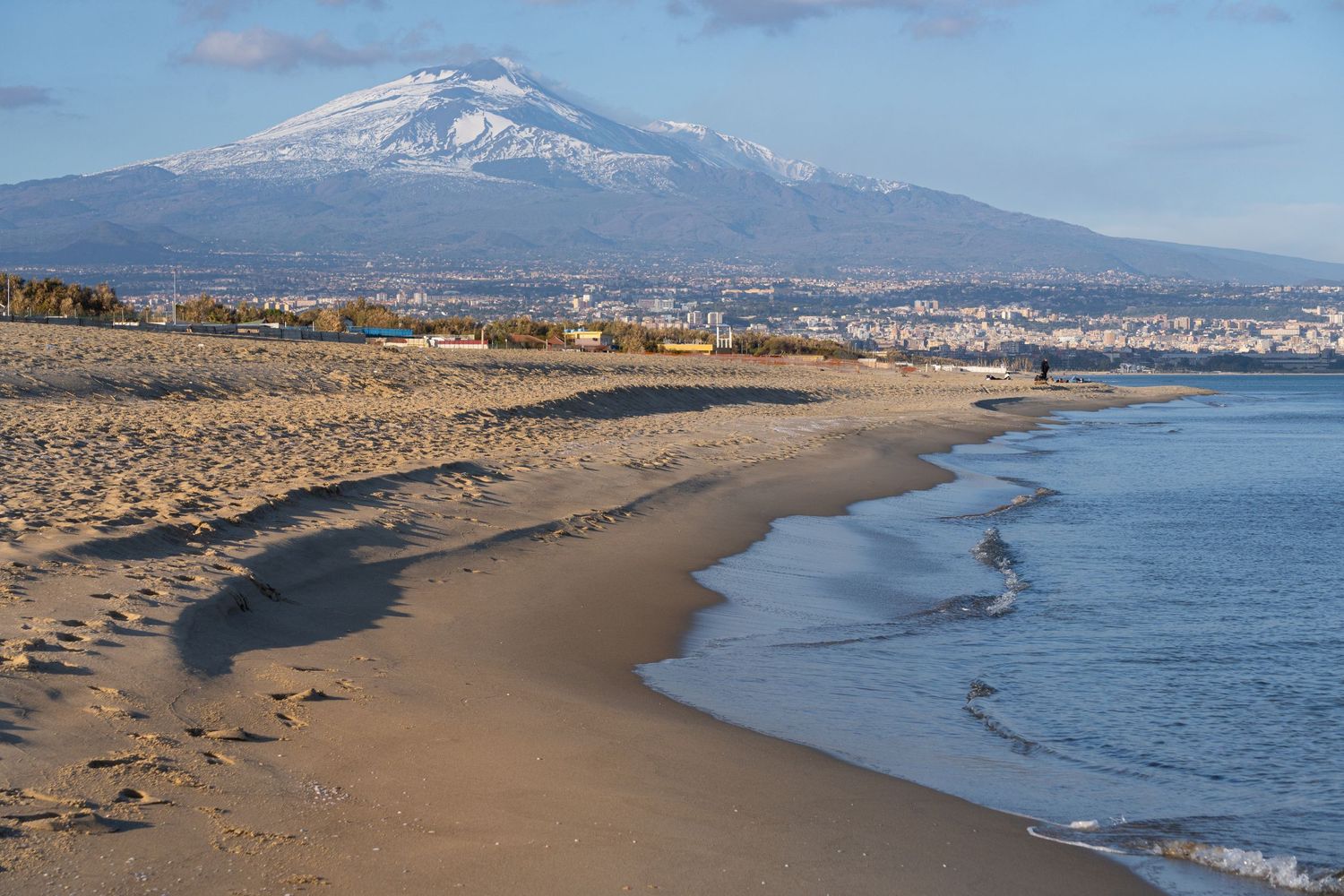 Playa di Catania, spiaggia di sabbia dorata con l’Etna sullo sfondo, fotografia naturalistica della Sicilia orientale.