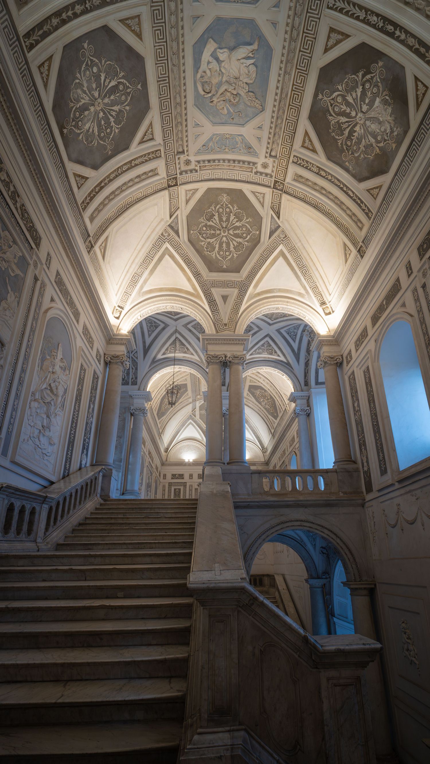 Scala barocca illuminata, monastero dei Benedettini, Catania, interno di palazzo storico, fotografia d’arte architettonica.