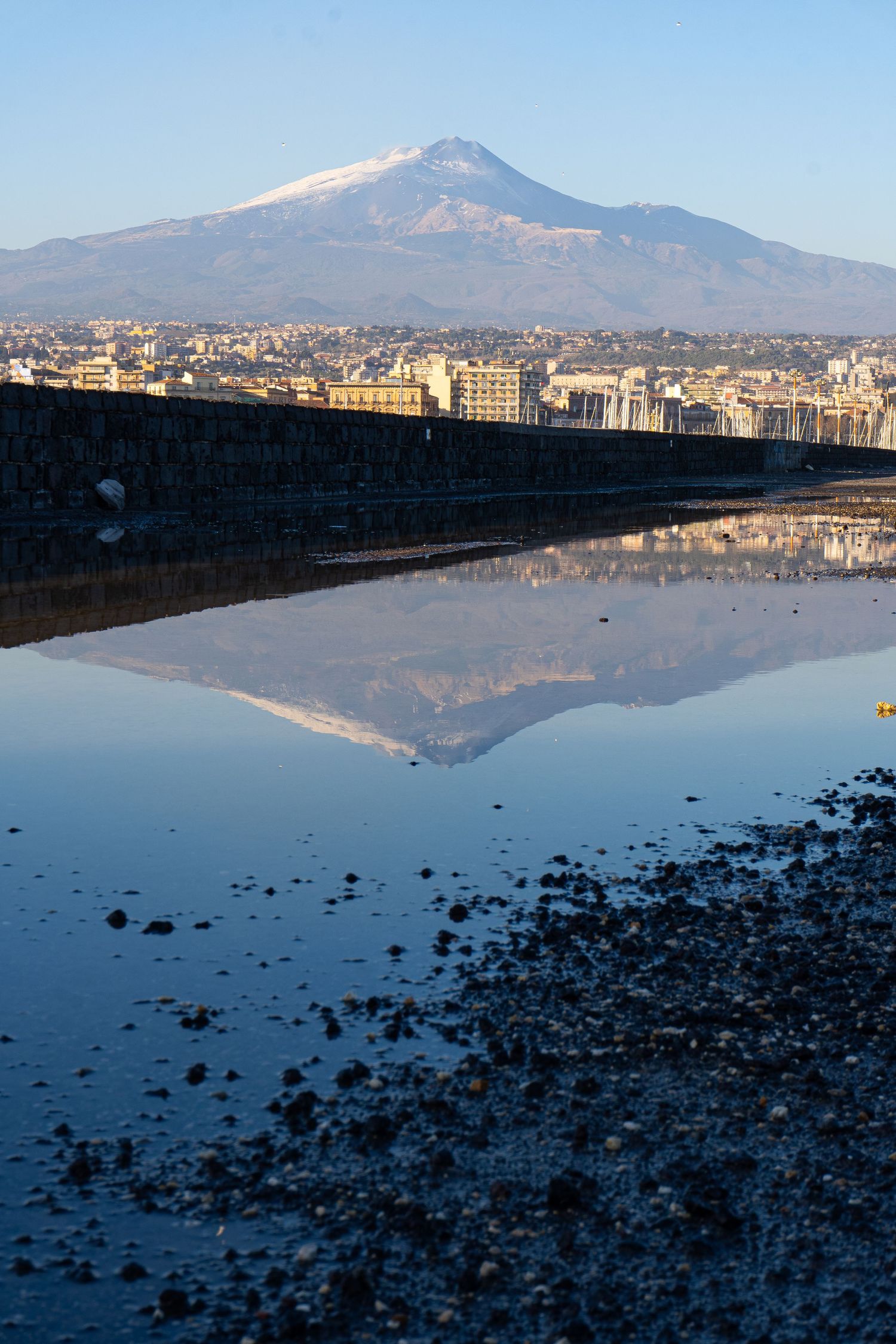 Riflesso dell’Etna in acqua sul porto di Catania, fotografia paesaggistica contemplativa.
