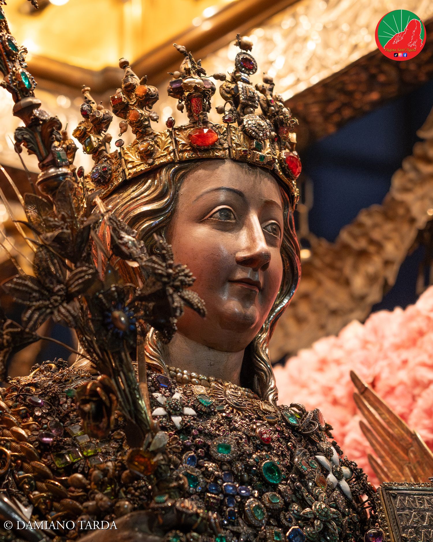 Primo piano notturno del busto reliquiario di Sant'Agata incastonato di gioielli e preziosi tradizionali a Catania