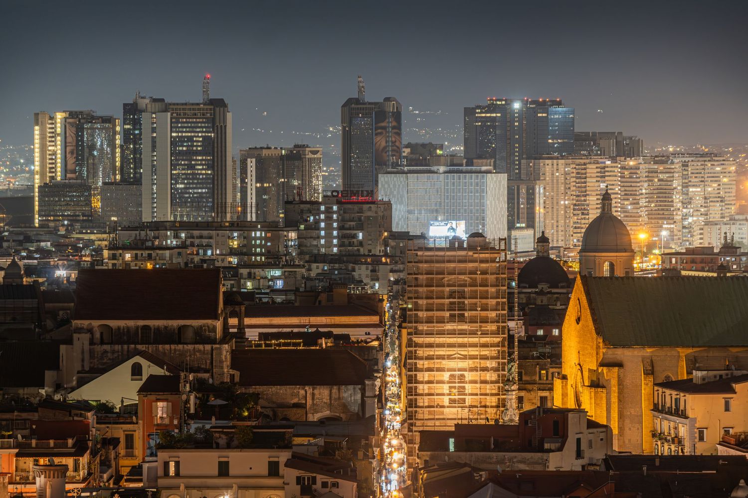 Skyline notturna Napoli centro, luci della città moderna, fotografia urbana contemporanea.