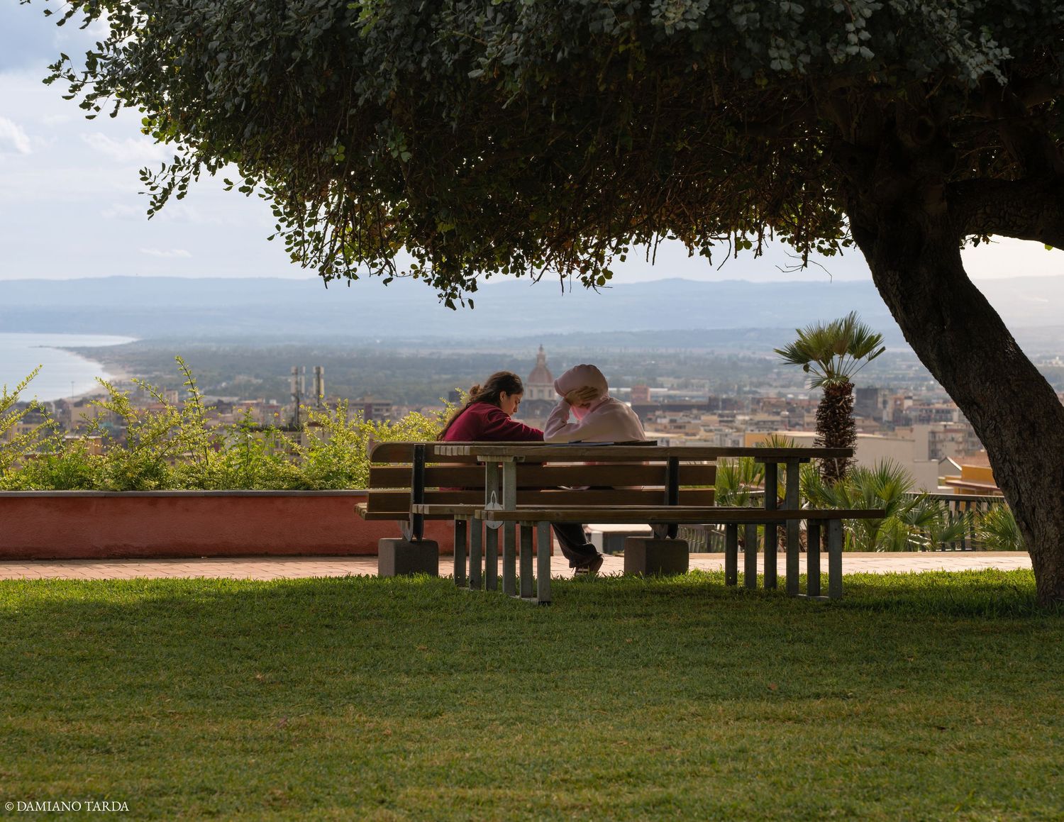foto panoramica di Catania, due ragazzi che conversano ammirando lo skyline
