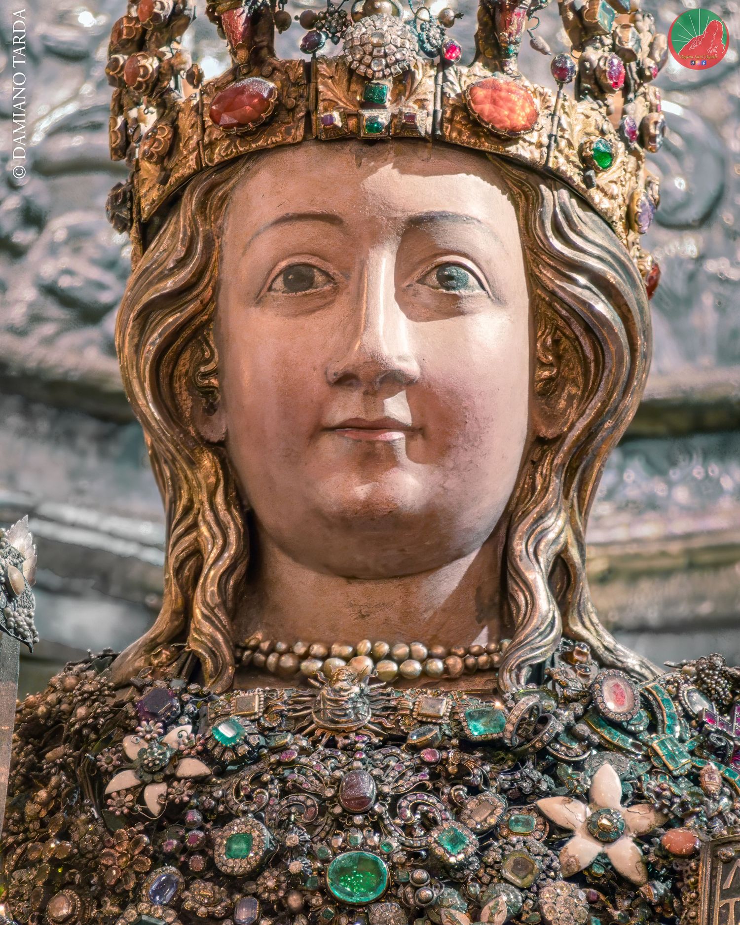 Primo piano del busto reliquiario di Sant'Agata incastonato di gioielli e preziosi ex-voto a Catania