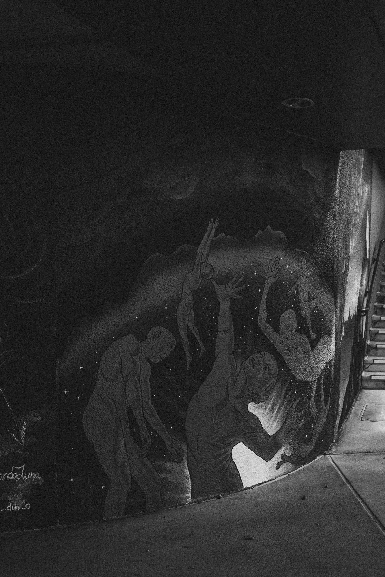 Silhouettes of people crouching and examining something in a dark space, creating a dramatic noir-style scene.