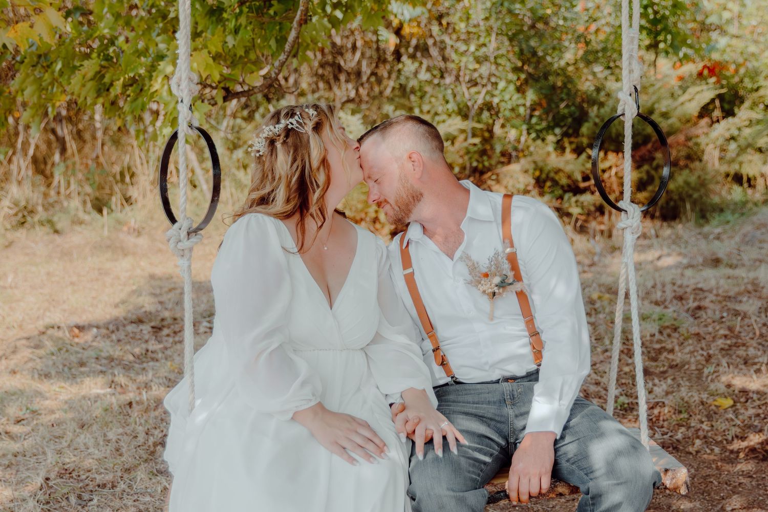 Couple in white outfits sharing intimate moments outdoors.