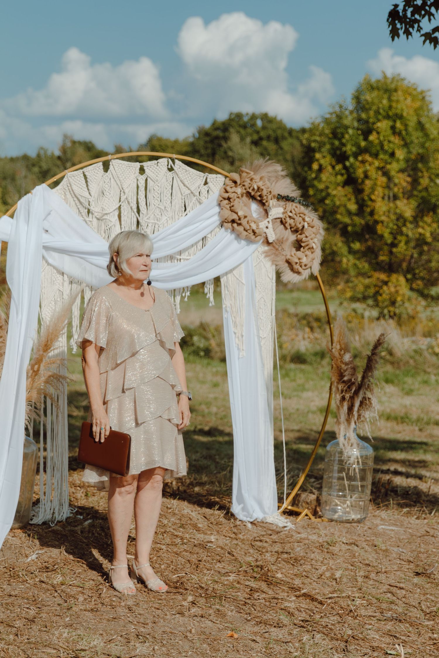 Outdoor wedding setup with white fabric draping and natural decor against a scenic backdrop.