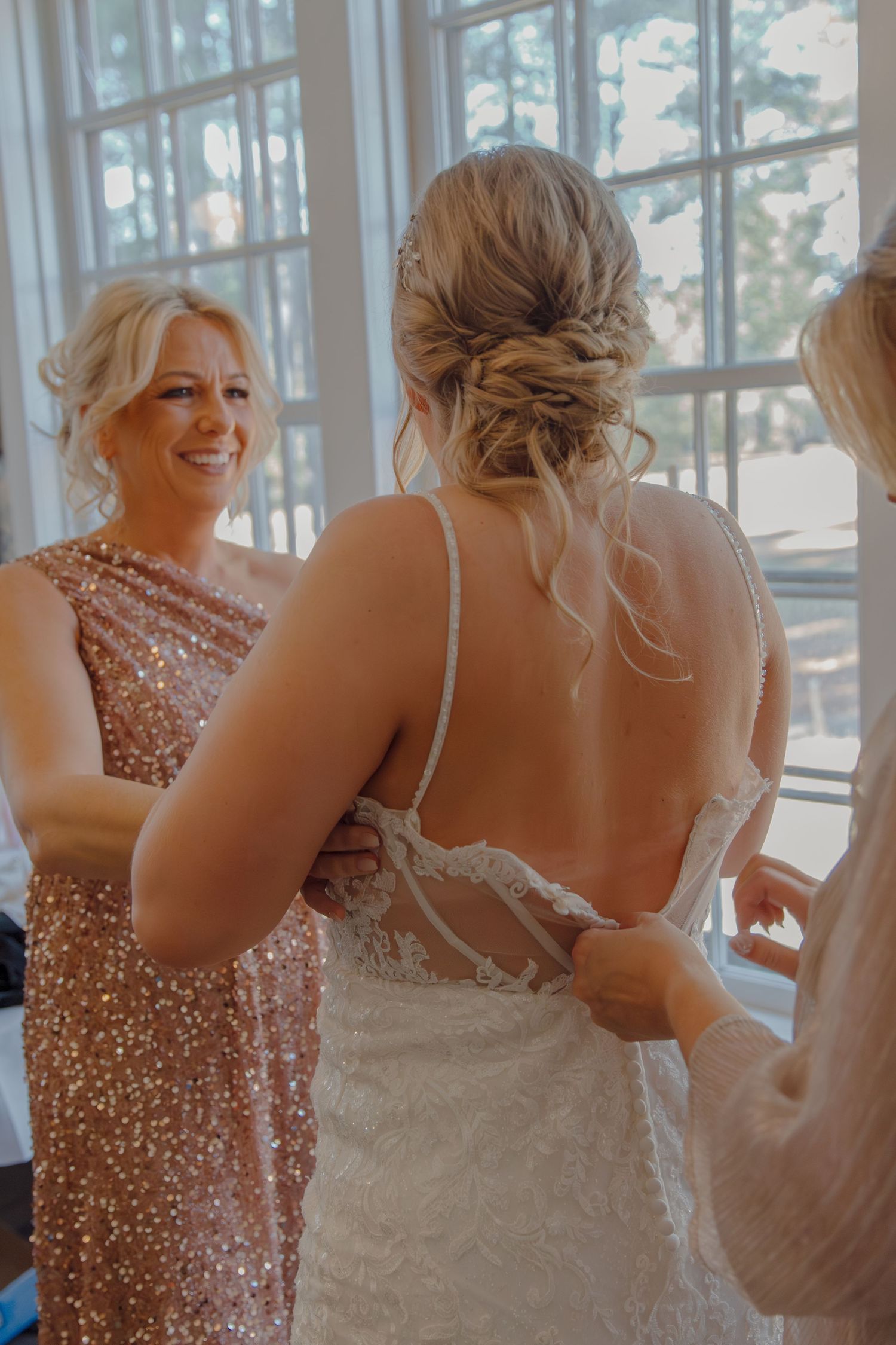 Getting ready scene with elegant formal dresses and natural window lighting.