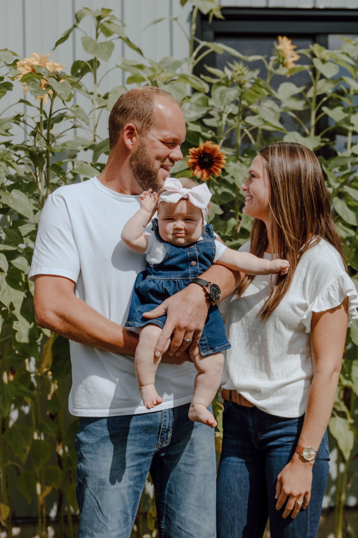 A joyful family moment captured in front of blooming sunflowers.