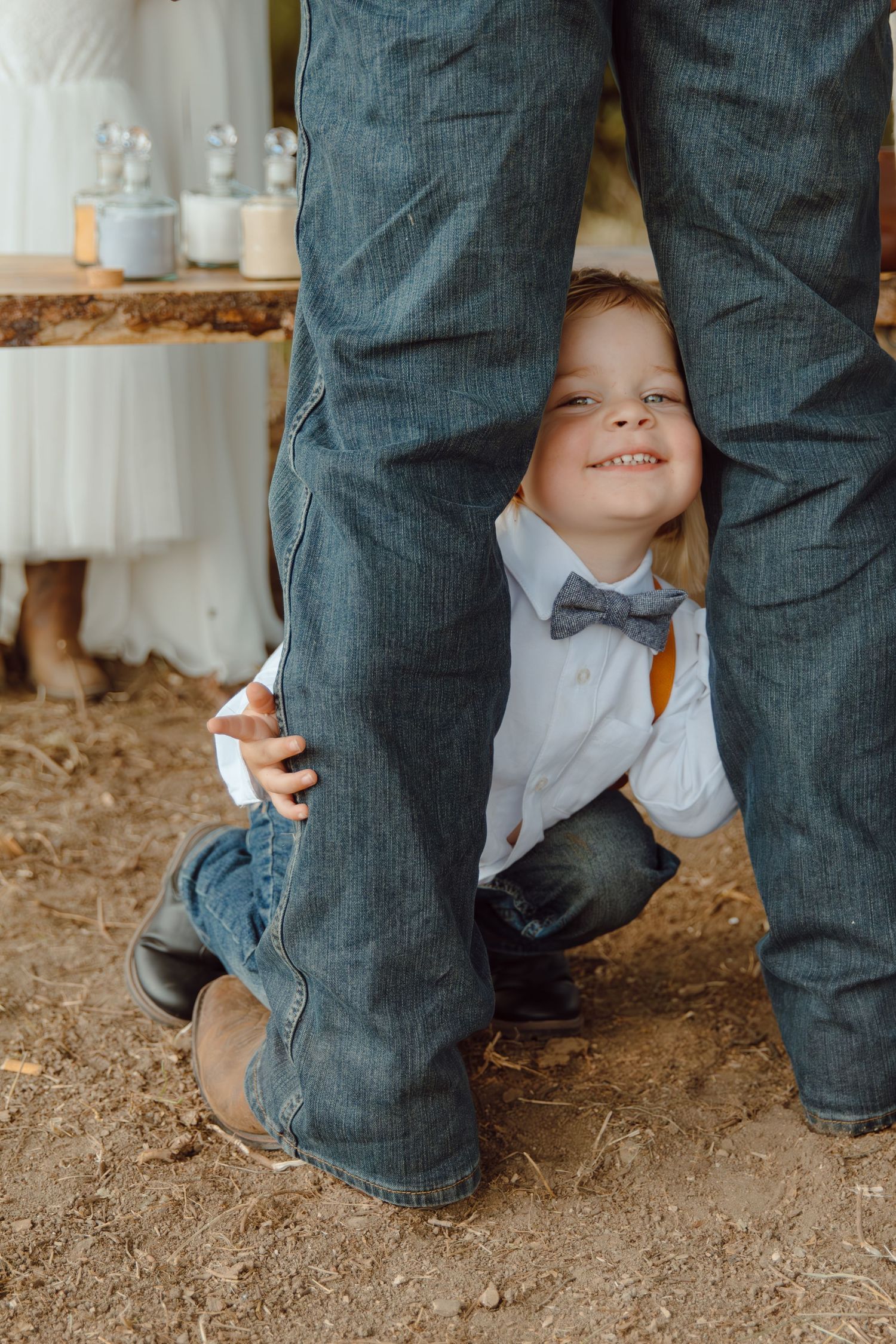 A candid low-angle shot showing playful interaction between legs and formal shoes.
