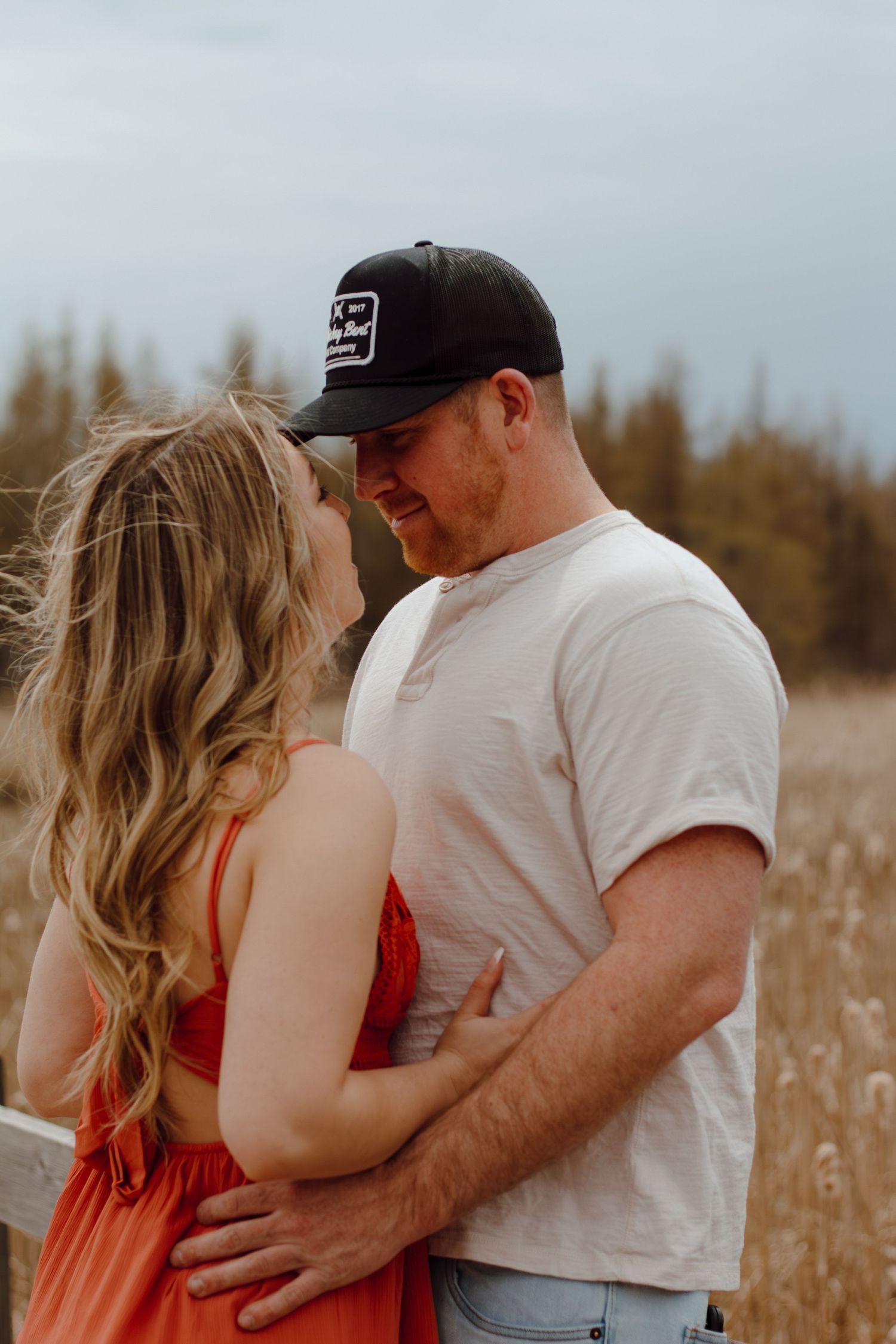 Romantic couple embracing in a golden field during sunset.
