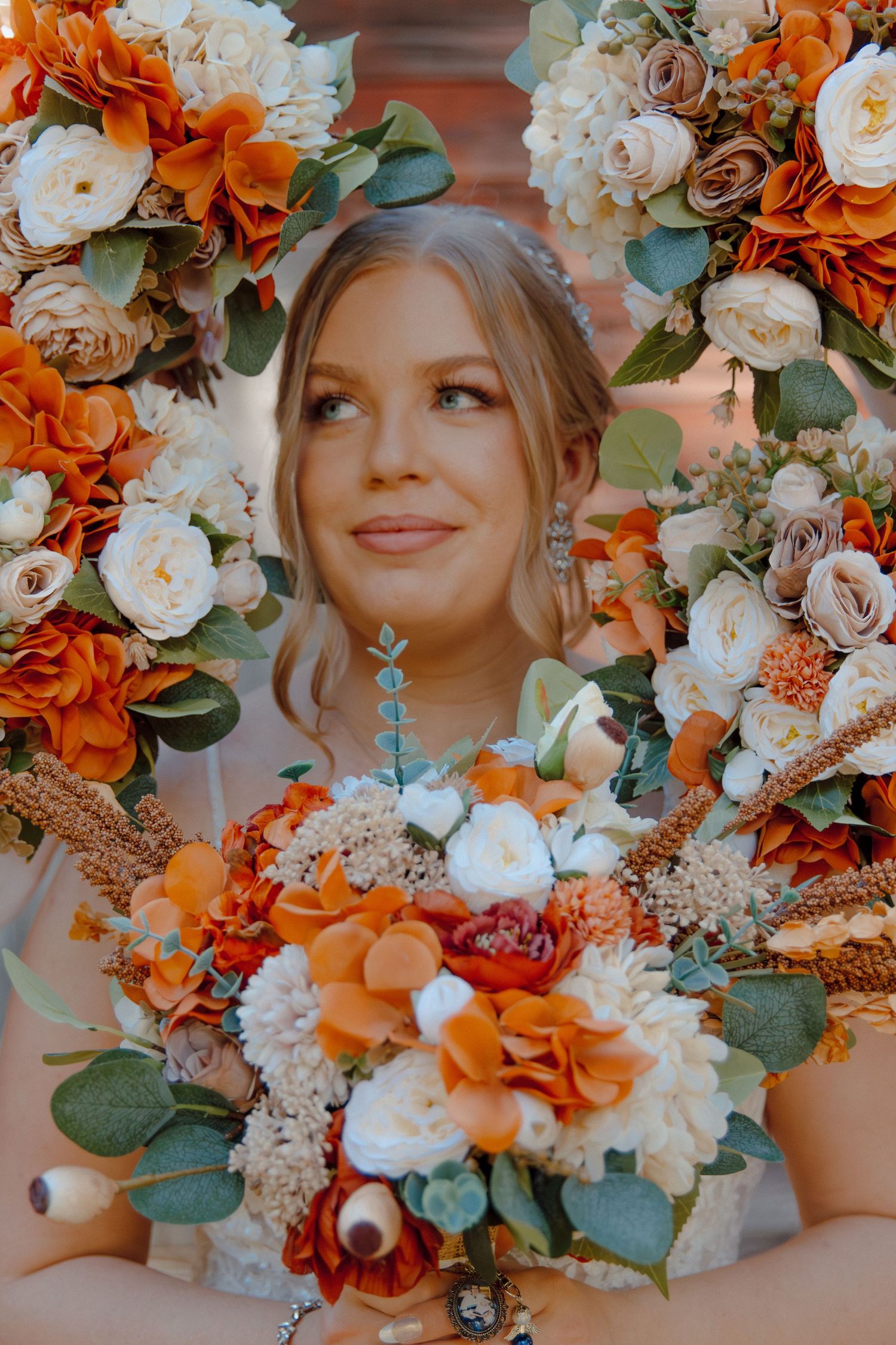 Wedding bouquet with orange and white flowers framing bridal portrait.