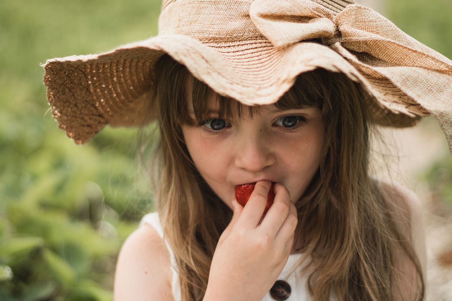 Series of candid expressions showing pure joy and laughter under a straw hat.
