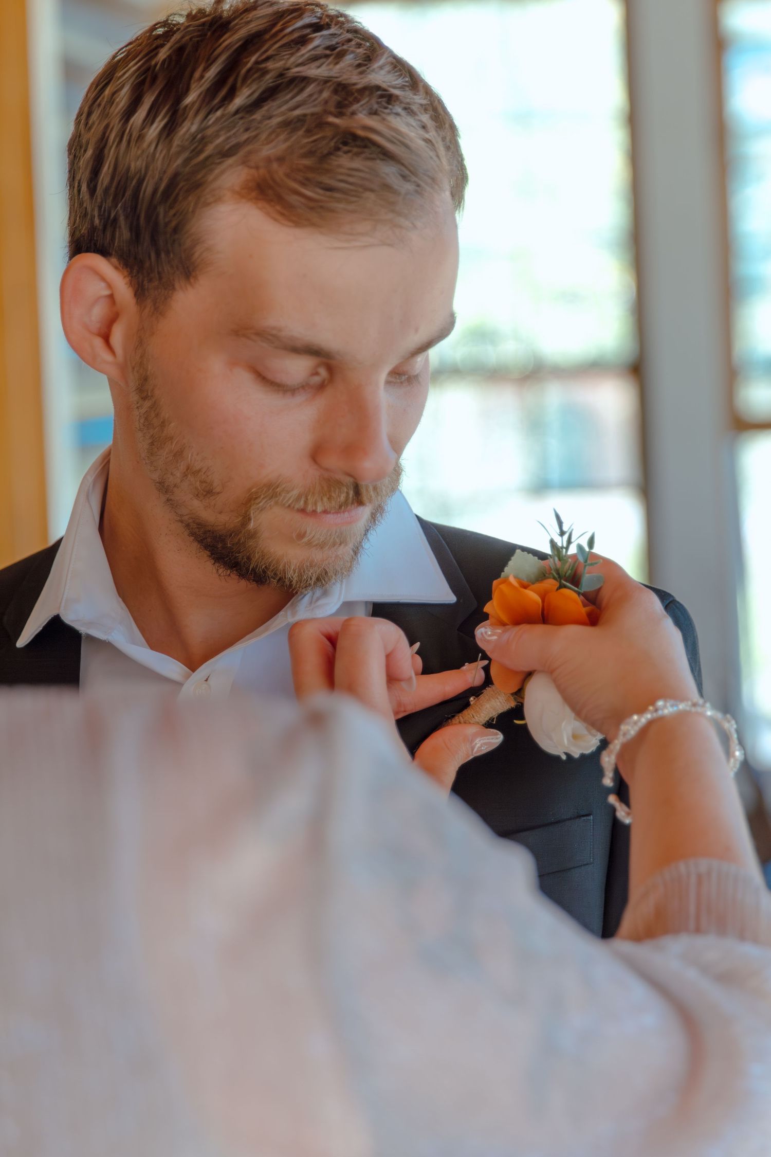 Close-up sequence of a groom adjusting his tie before the ceremony.