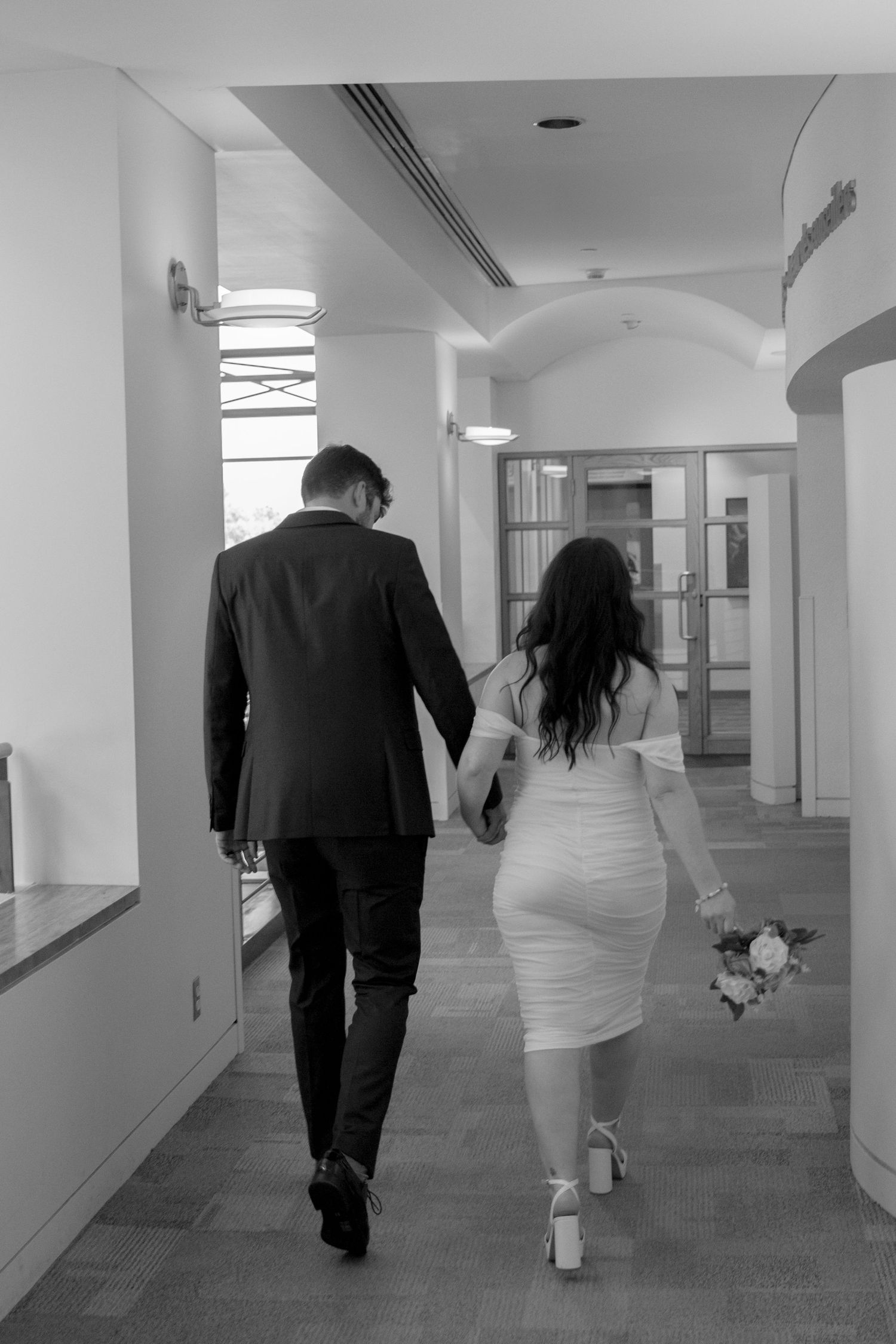Black and white photo sequence of a couple walking down a hallway.