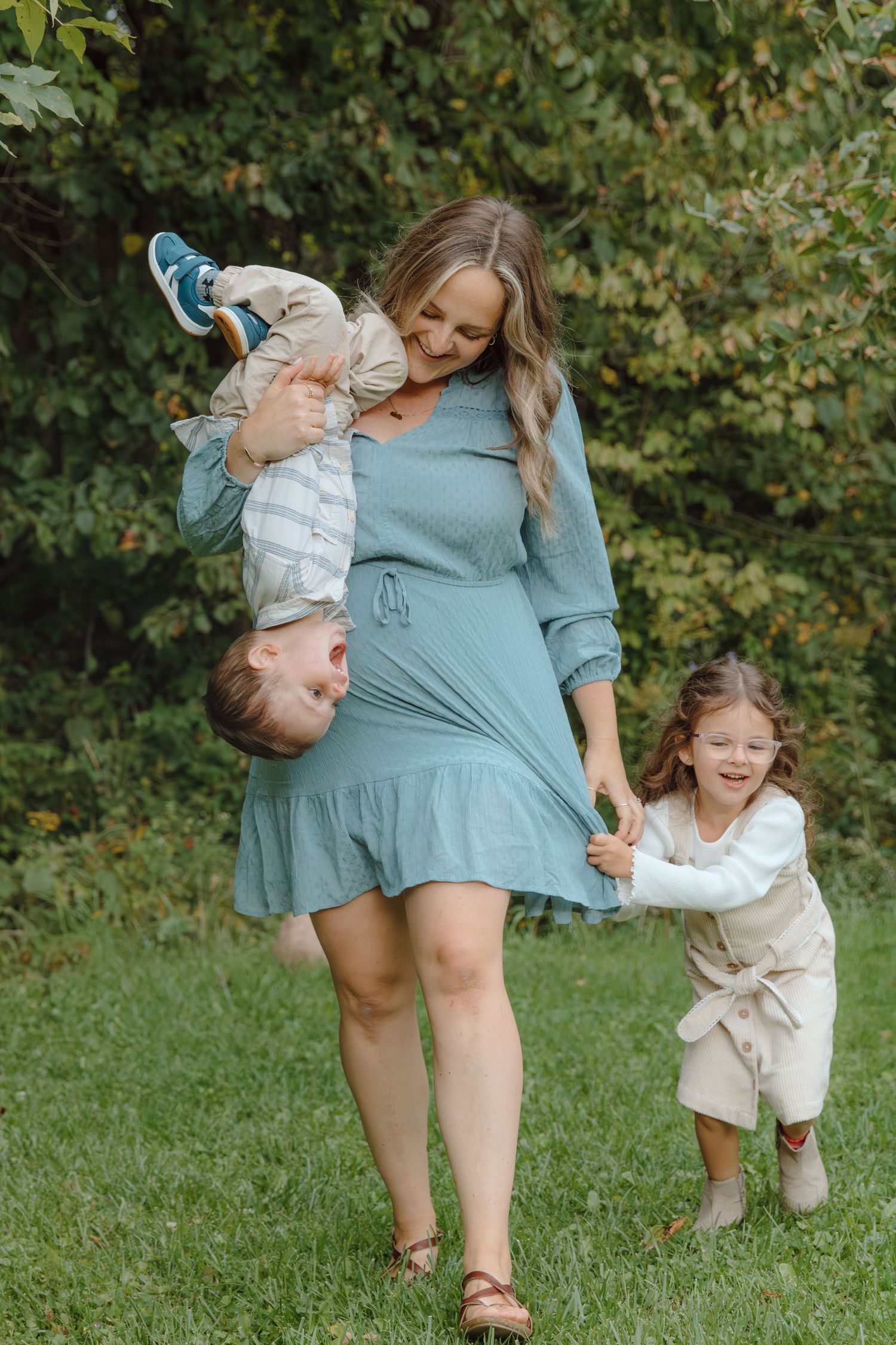 Family playtime outdoors with coordinated blue and white outfits against a natural backdrop.