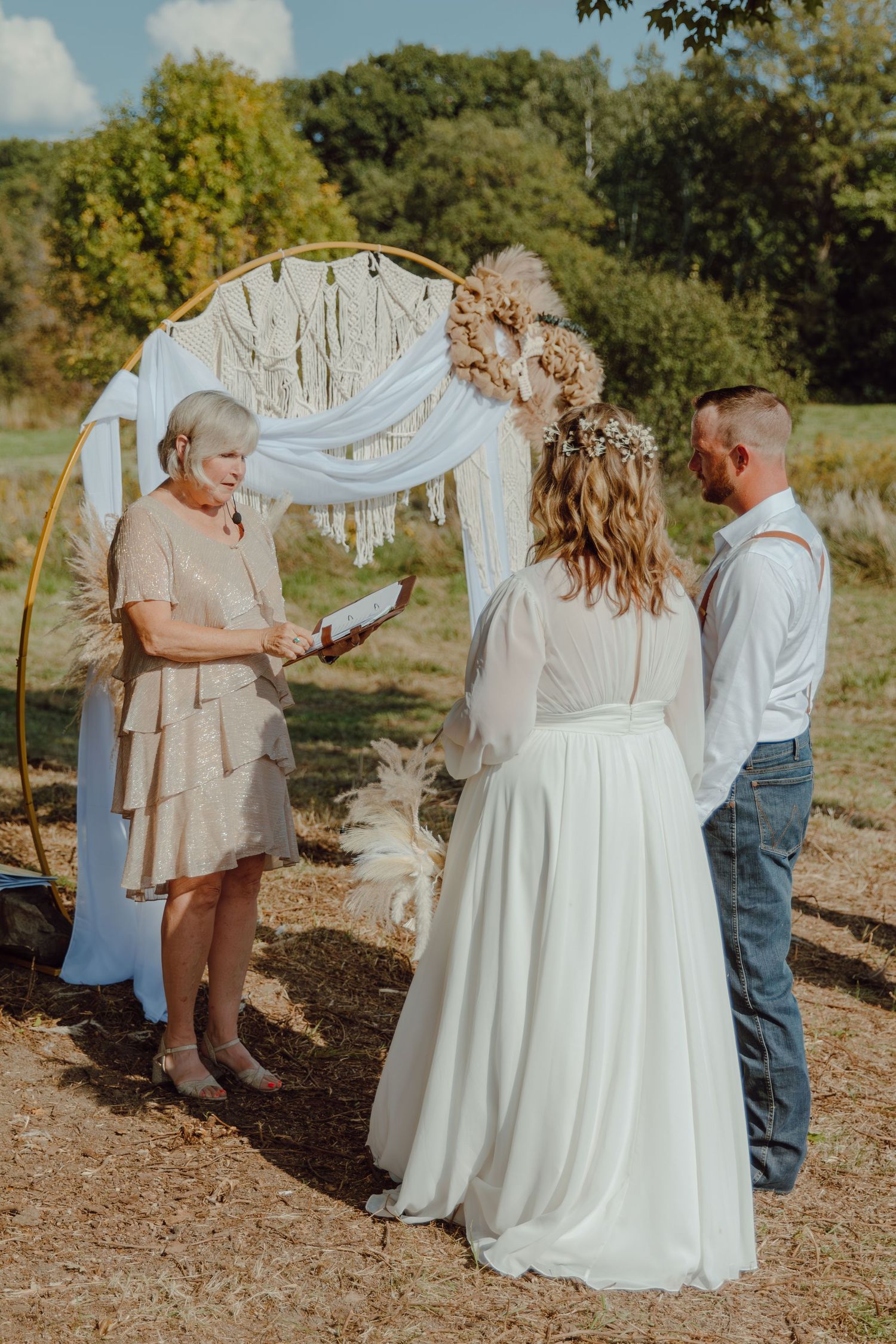 An intimate outdoor wedding ceremony moment with guests watching.