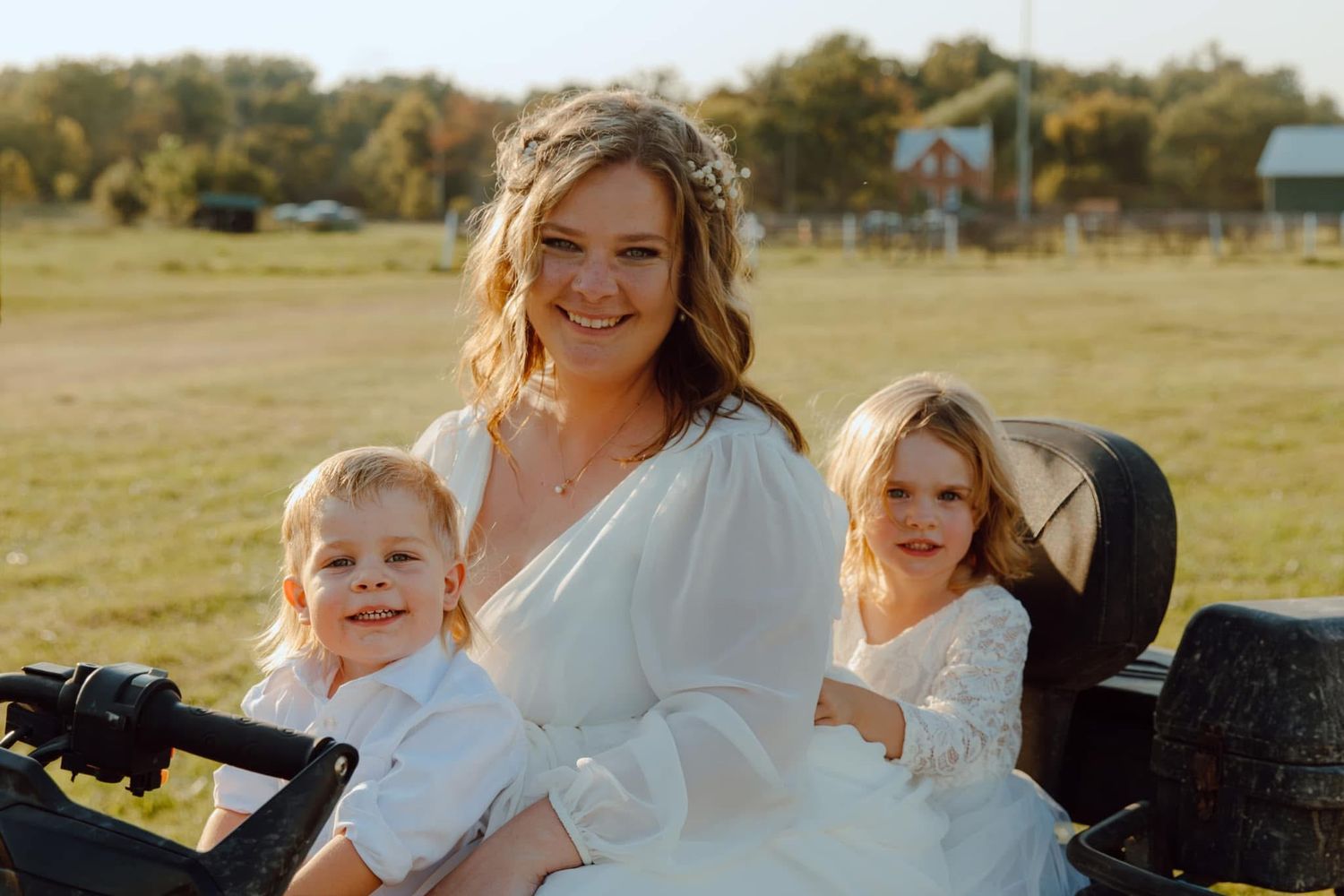 Wedding celebration with family members on grassy field during golden hour.