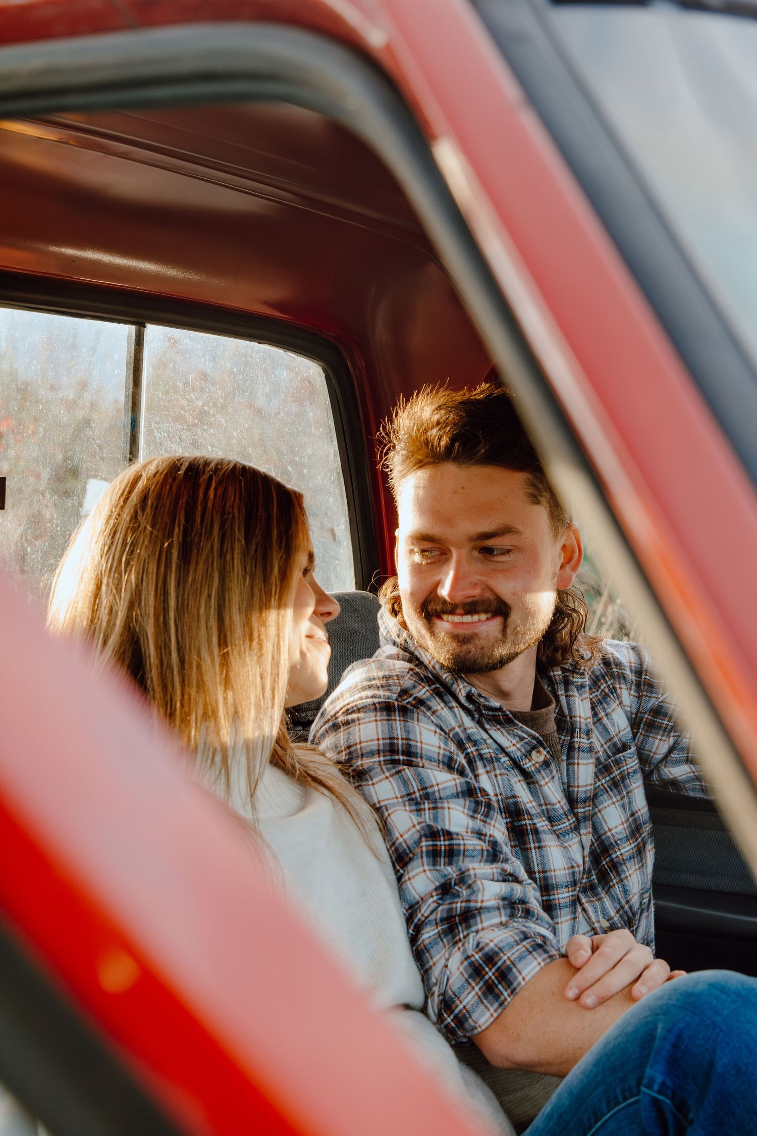 Couple enjoying each other's company in the front seat of a car.