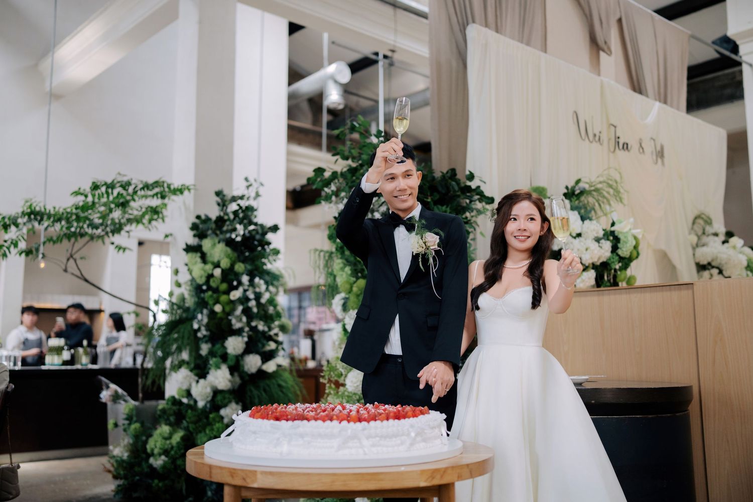 Couple raising glasses to guests during their Peninsula House Penang wedding dinner