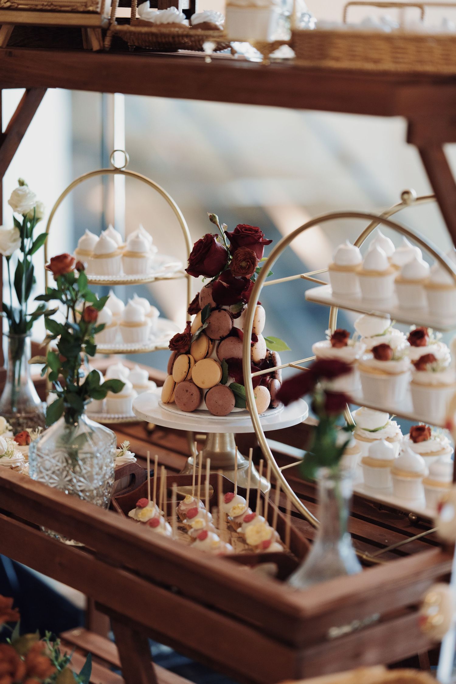 Elegant wedding dessert display featuring a macaron tower and white cupcakes for a luxury reception