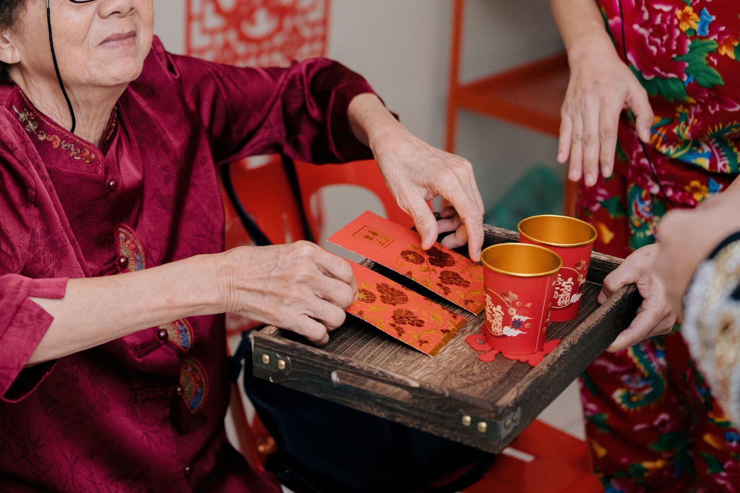 Traditional Chinese tea ceremony ritual where an elder exchanges red envelopes for tea as a symbol of blessing and respect