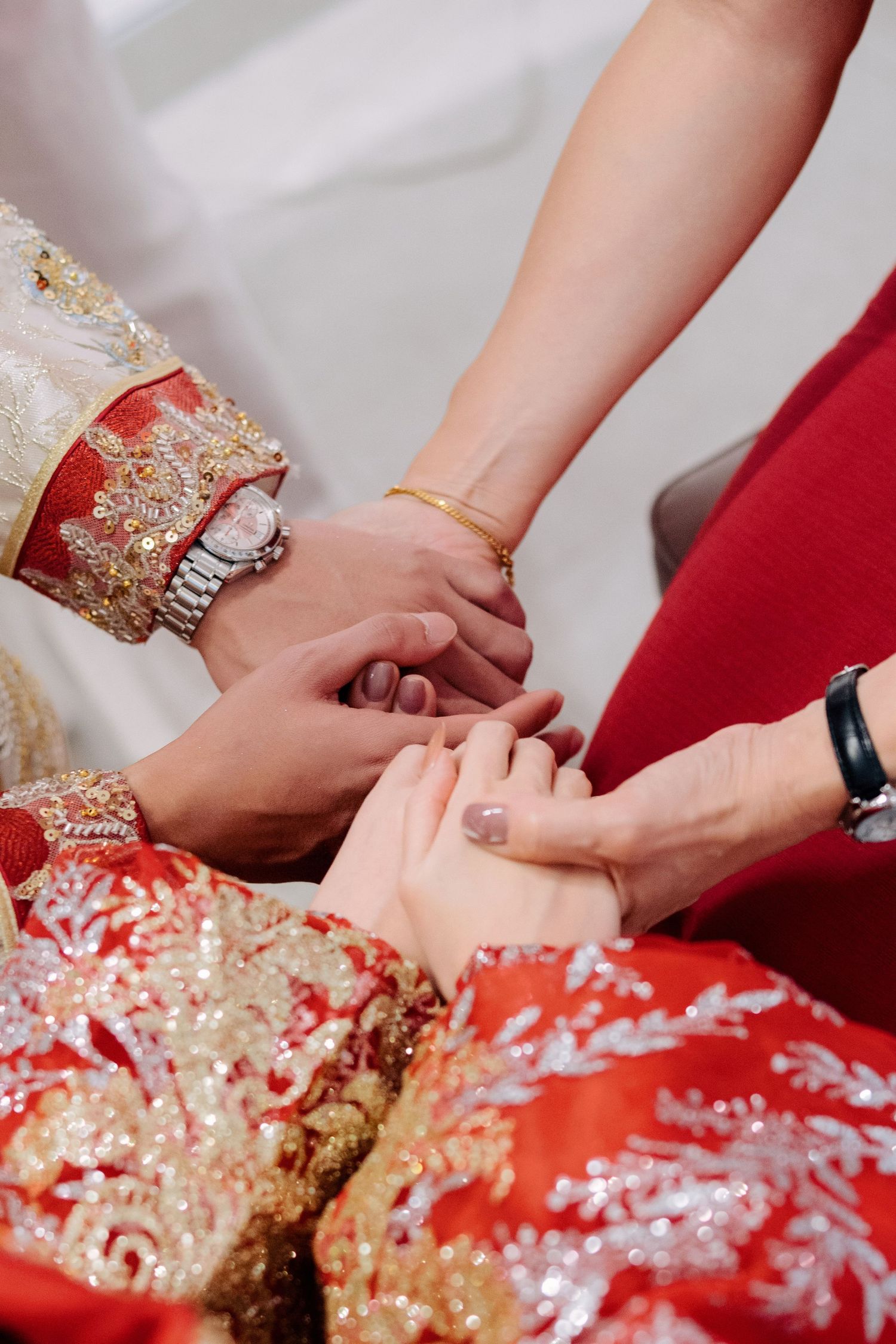 Traditional Chinese tea ceremony showing hands exchanging tea cups with red and gold decorative elements.