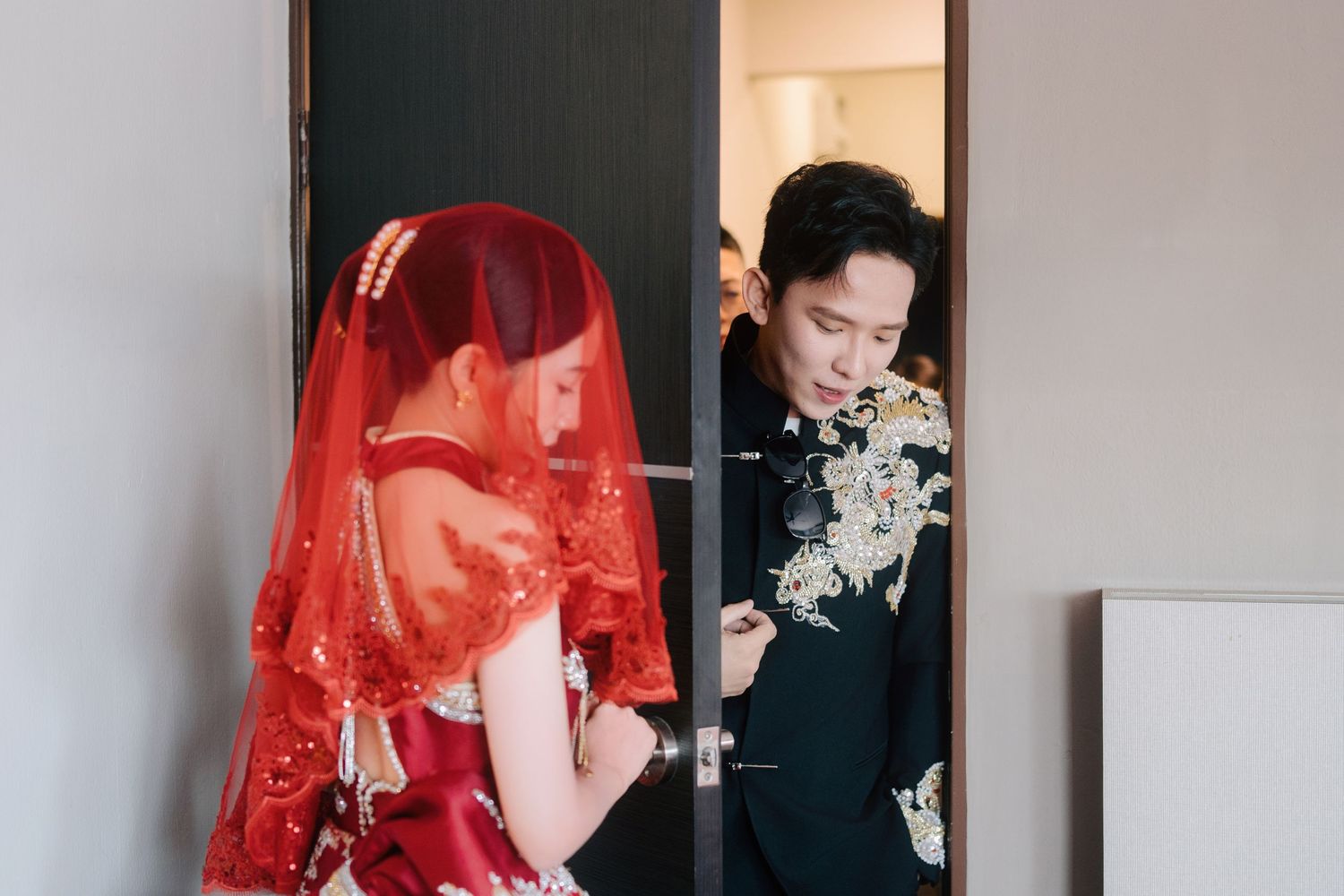 Groom and bride interacting at the door during a traditional Chinese wedding gatecrashing
