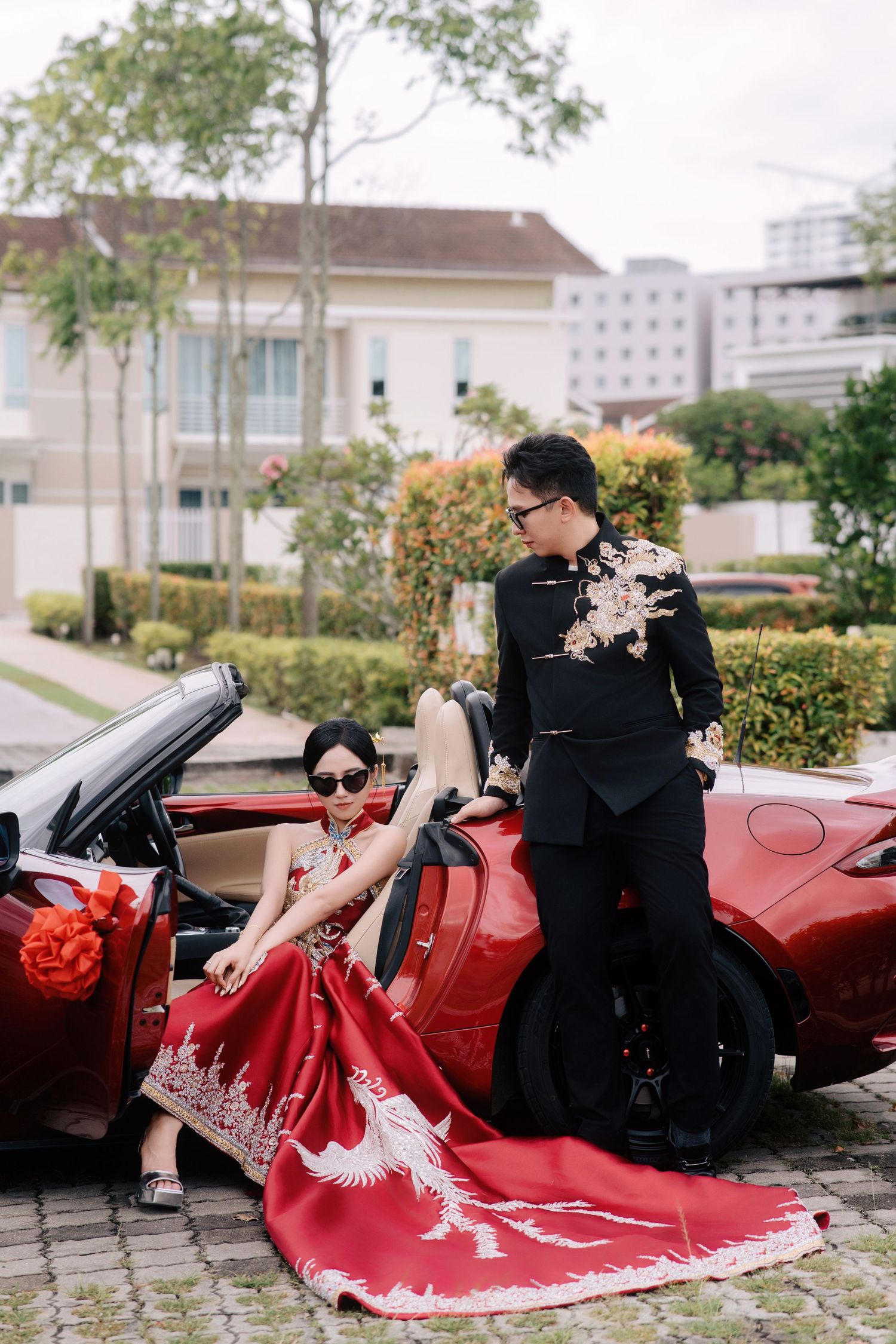 Traditional Chinese wedding dress with a long phoenix-embroidered train displayed on pavement