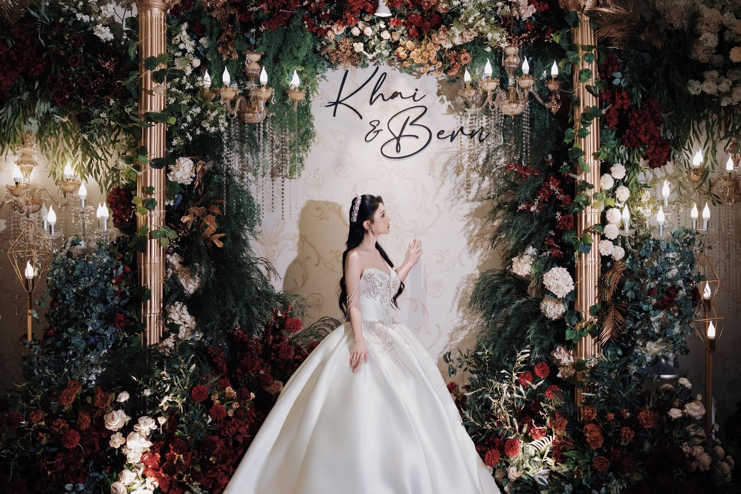 Bride at a floral wedding photo booth with enchanted forest decor and personalized signage