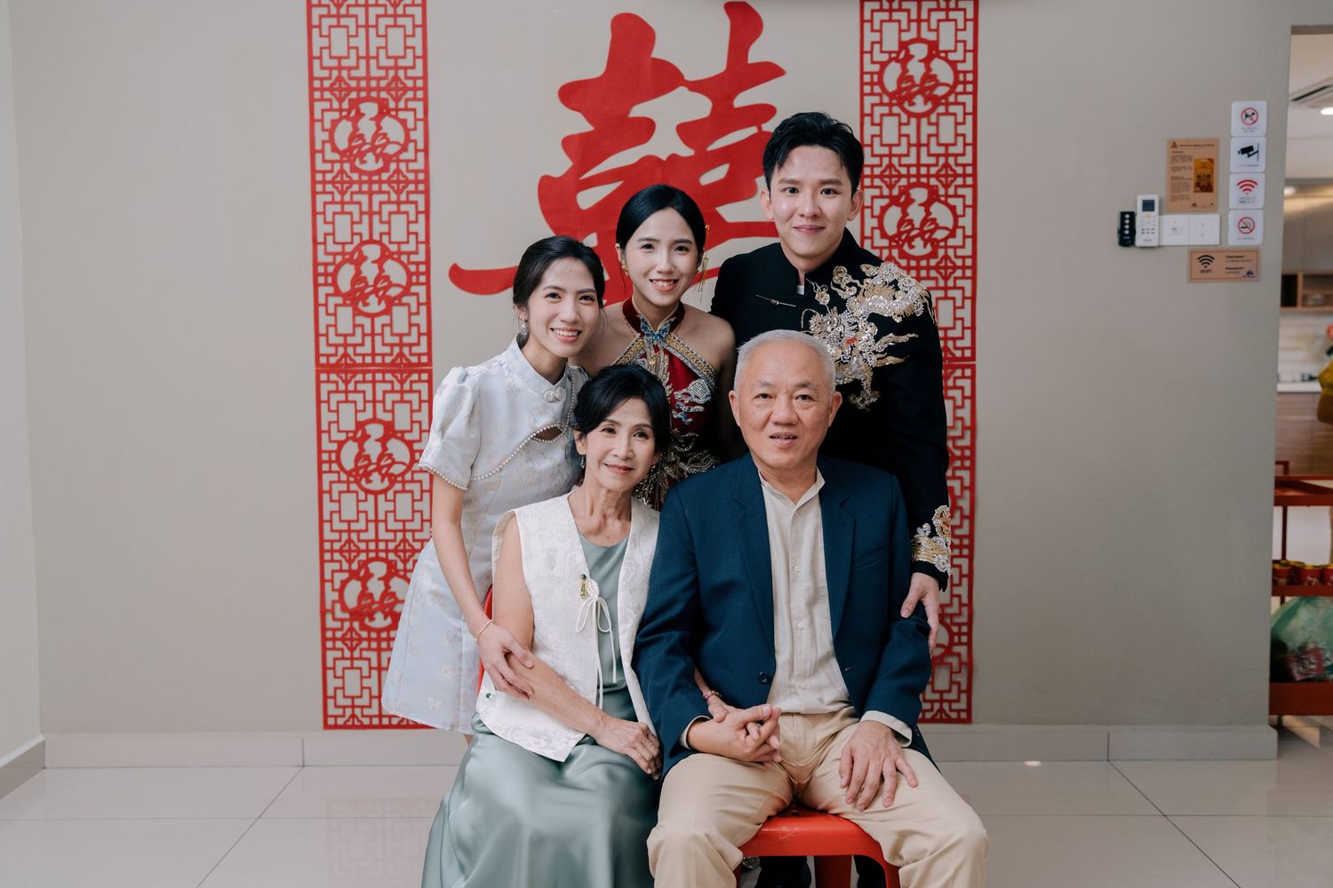 A family portrait during a Traditional Chinese Wedding in Penang featuring the couple in modern embroidered Oriental outfits