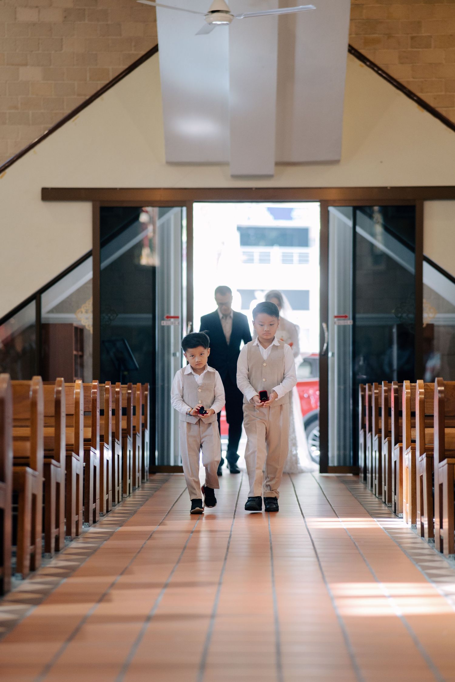Page boys lead the bridal entrance down the aisle during a traditional church wedding ceremony