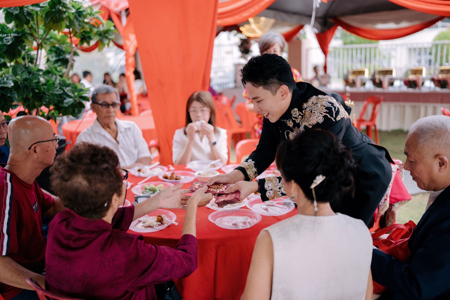 Groom distributing red packets to elders, a key custom of a Traditional Chinese Wedding