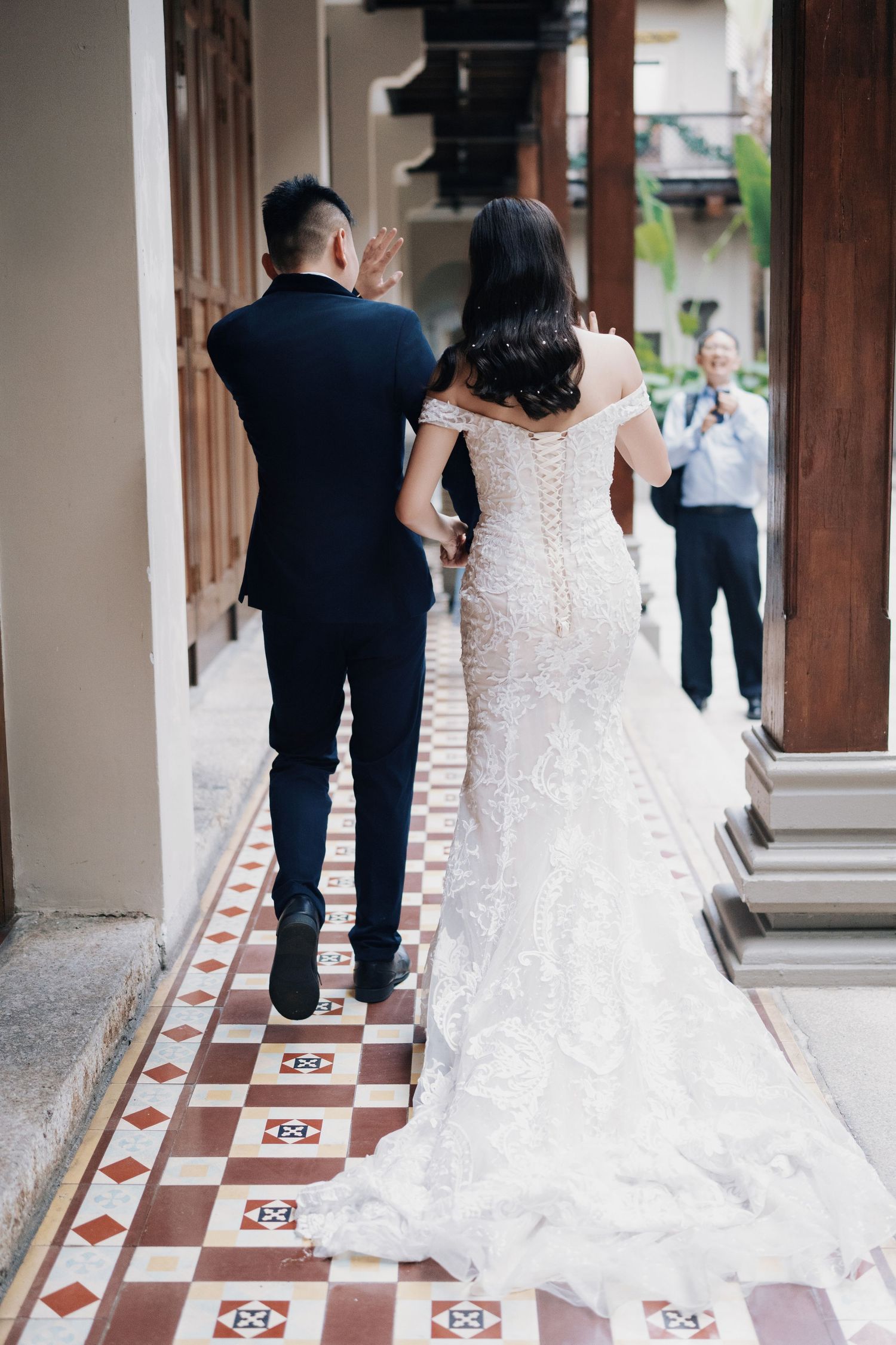 Intricate Peranakan floor tiles at a Seven Terraces Penang wedding venue with the couple walking